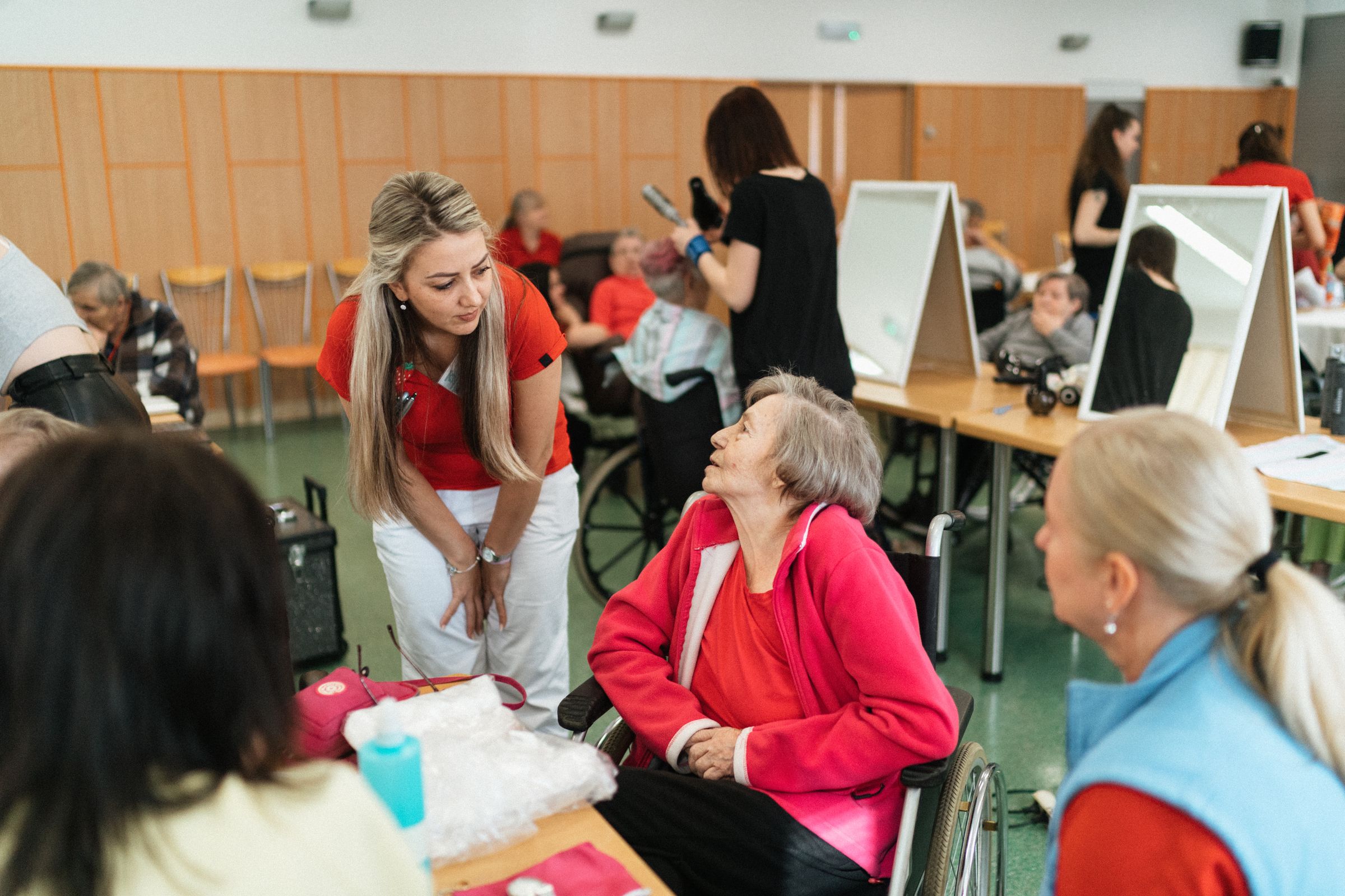 A support worker speaking with an older wheelchair user during a community activity